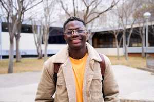 A young man is smiling at the camera.